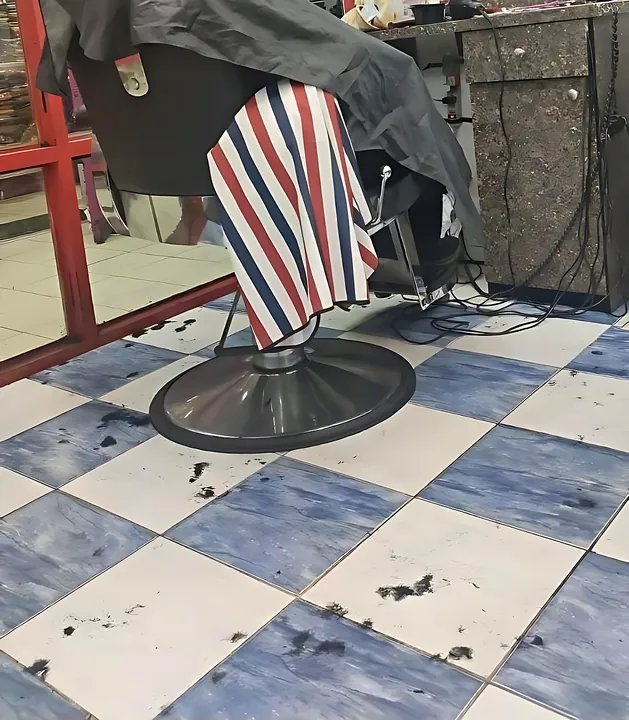 Barber chair with a customer under a striped cape
